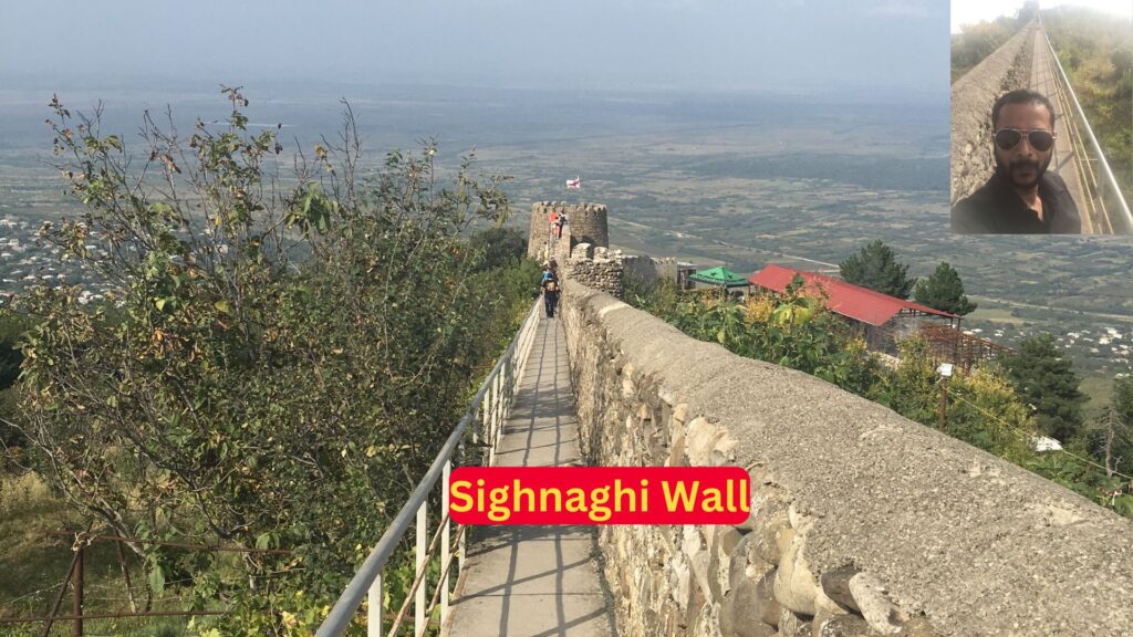 Man taking a selfie in front of the Sighnaghi Wall in Georgia.